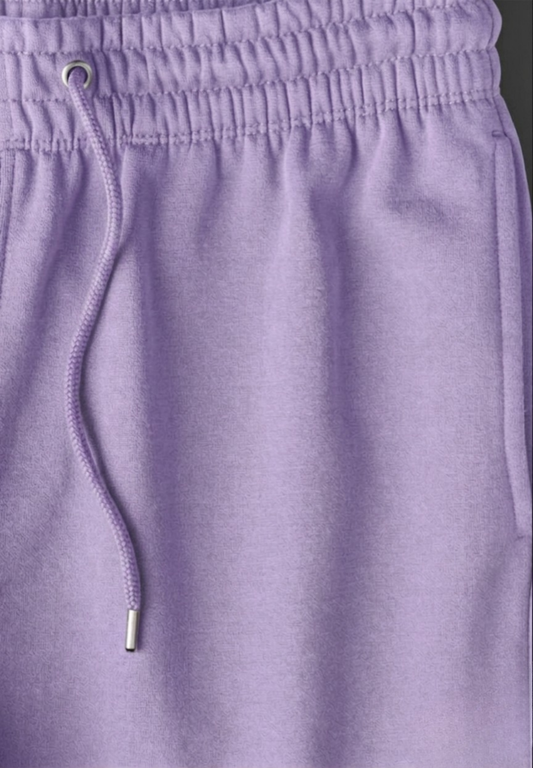 Close-up of purple pants with a drawstring and button.